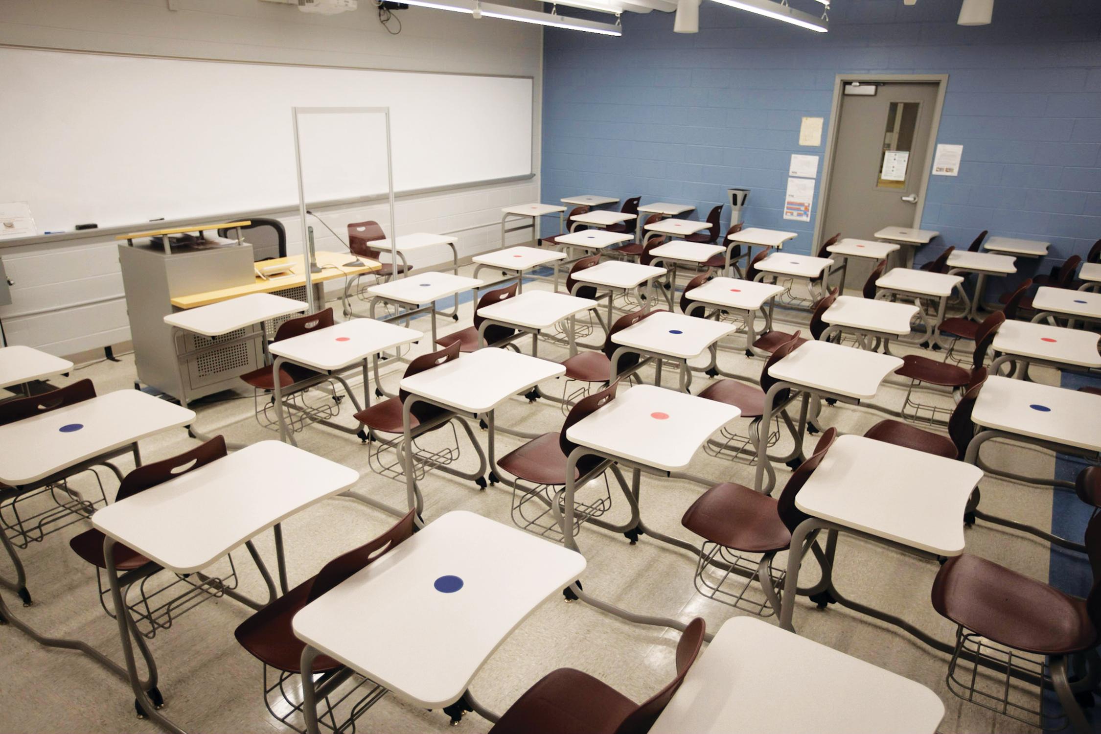 To facilitate social distancing, seating is designated according to colored dots on student desks.