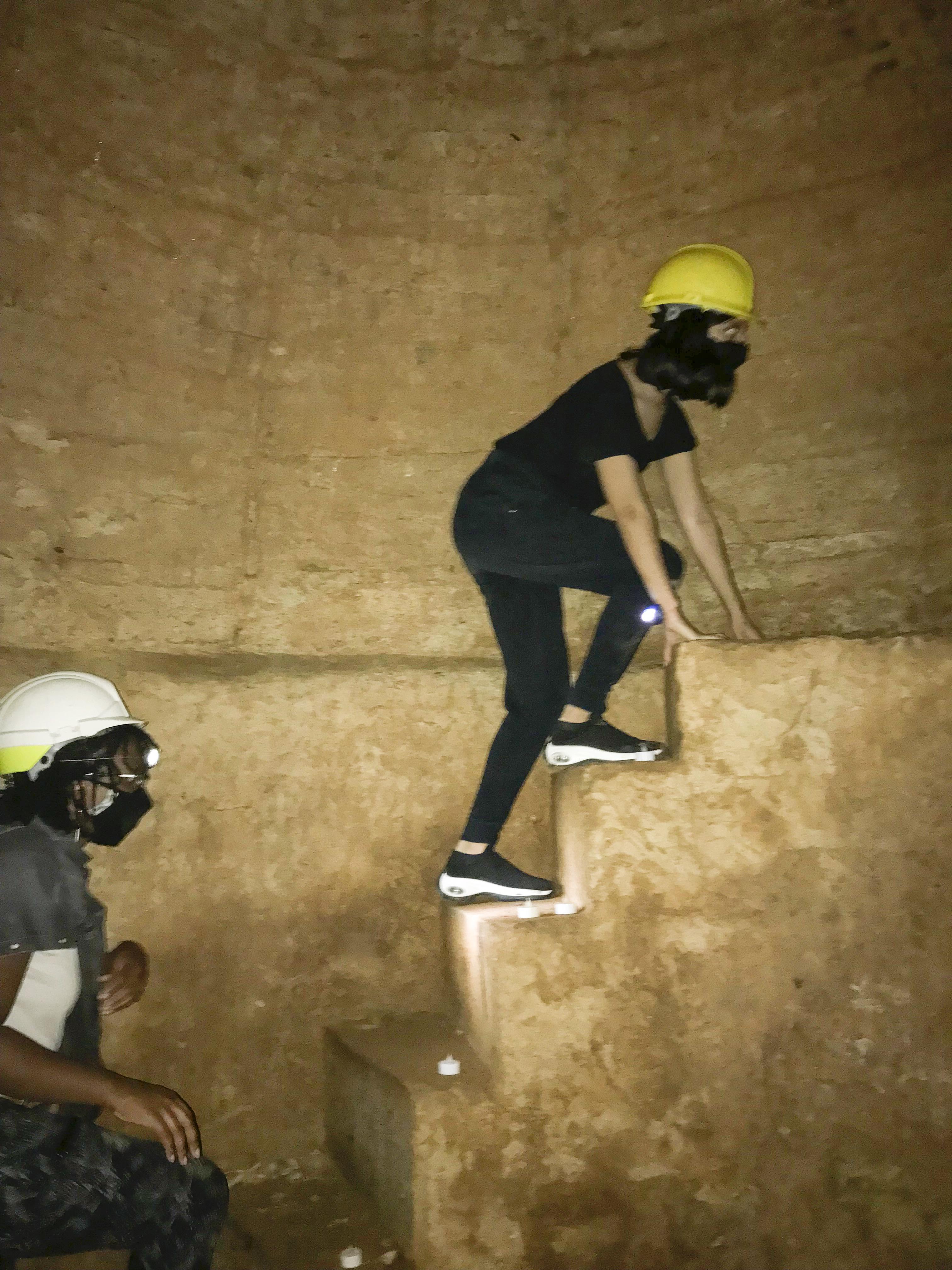 Iman Syed ’22 ascends a staircase inside Hadrian’s Aqueduct beneath the city of Athens, while Ebony Payne ’22 looks on.