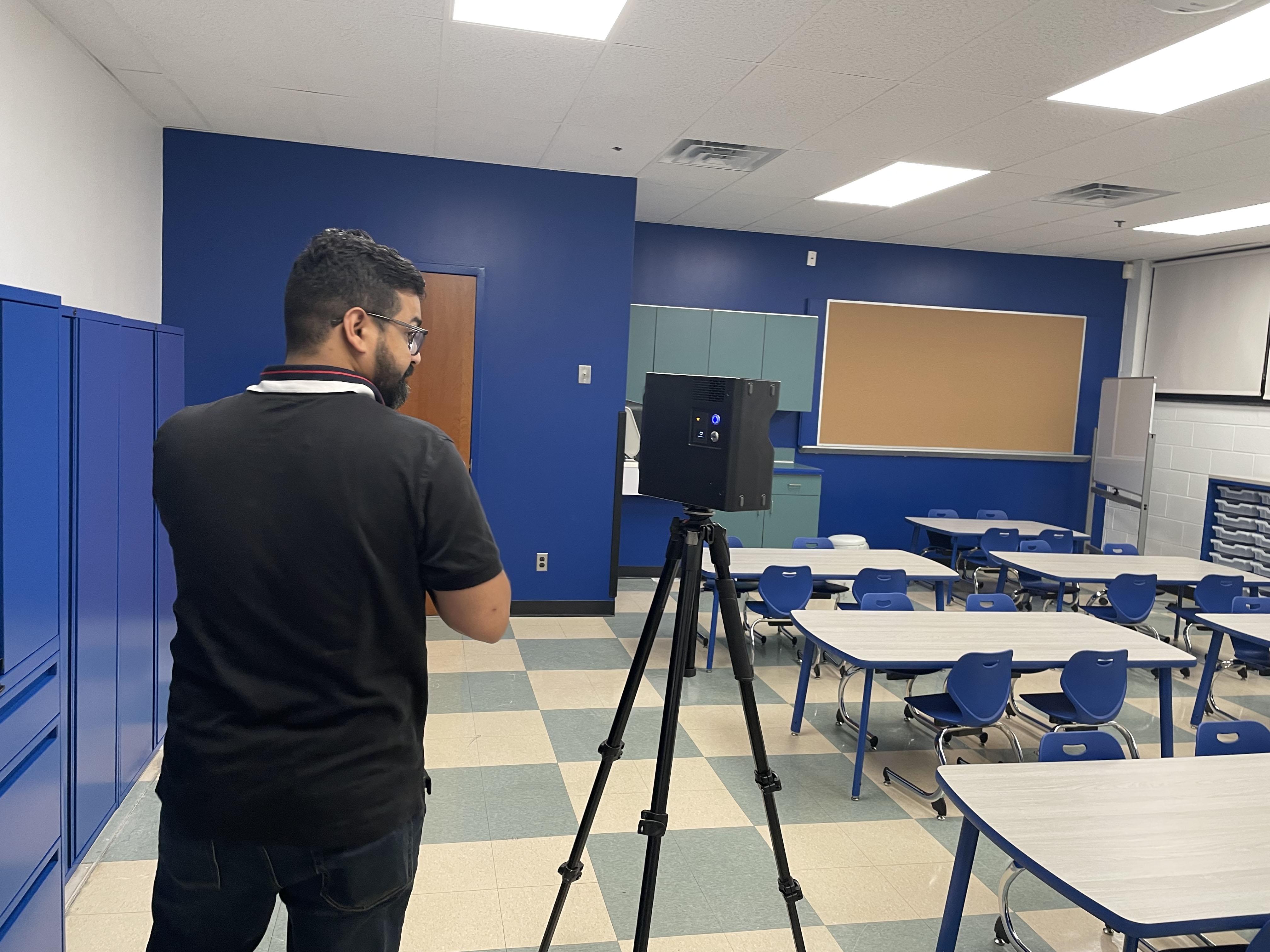 Satia Anand&nbsp;B.Arch. ’23, operating a Matterport camera to document a classroom.