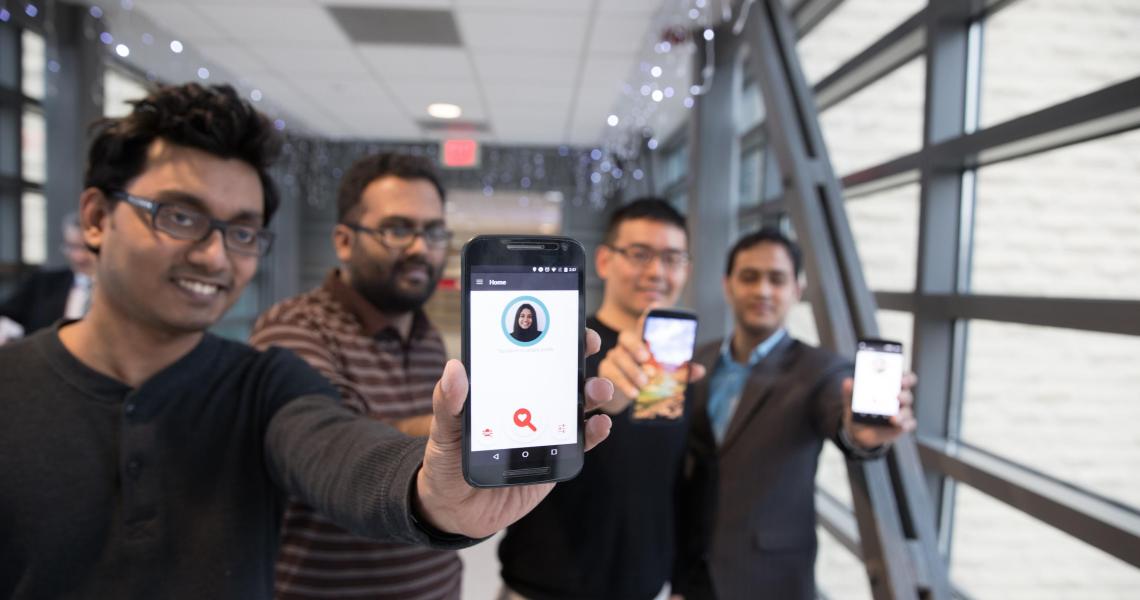 four students hold up smartphones featuring FaceDate